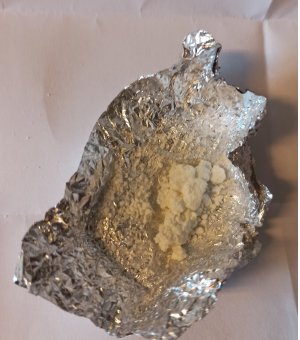 Zdjęcie przedstawiające folię aluminiową z zawartością białego proszku