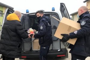Zdjęcie przedstawiające paczki przekazywane przez policjantów