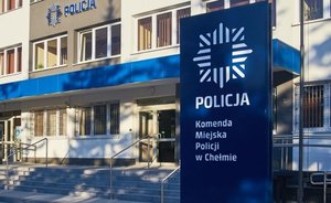 Zdjęcie wejścia do siedziby jednostki Policji, na pierwszym planie logo Policji z napisem Komenda Miejska Policji w Chełmie.