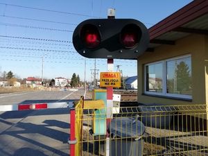 zdjęcie przejazdu kolejowego z widocznymi zaporami i sygnalizatorami