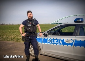 Policjant stojący przy radiowozie