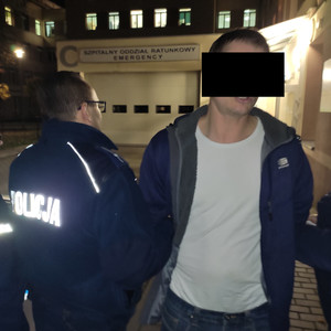 Mężczyzna z zasłoniętą twarzą oraz umundurowany policjant