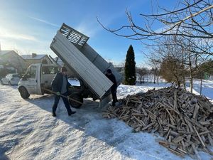 Dzielnicowy dostarczający drewno dla potrzebującego