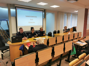 Sala konferencyjna, przy stole prezydialnym trójka umundurowanych policjantów.