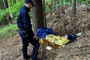 Policjant z uratowanym mężczyzną w lesie