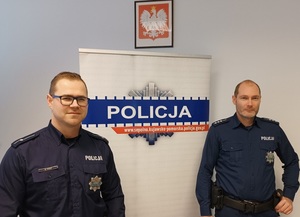 Dwaj policjanci na tle banera Policja