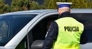 Zbliżenie policjanta kontrolującego samochód osobowy