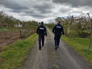 Dwóch umundurowanych Policjantów w ogródkach działkowych