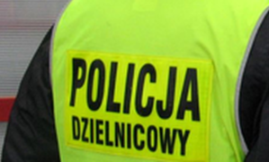 Policjant w żółtej odblaskowej kamizelce z napisem &quot;Policja dzielnicowy&quot;