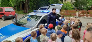 policjantka obok radiowozu i grupa dzieci
