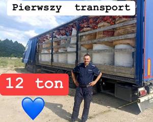 Dzielnicowy na tle ciężarówki wypełnionej nakrętkami