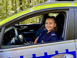 Zbliżenie uśmiechniętej policjantki w radiowozie