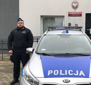 Policjant obok radiowozu