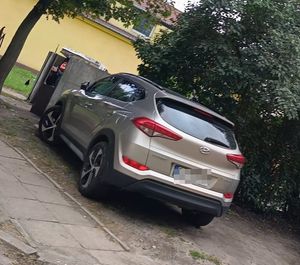 Pojazd typu SUV zaparkowany przed blokiem