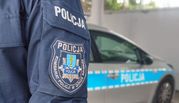 naszywka policyjna na kurtce służbowej policjanta w tle radiowóz