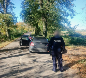 Umundurowany Policjant w tle samochód