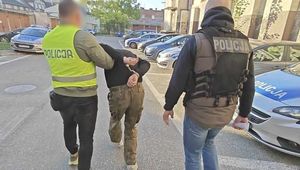 Policjanci prowadzą zatrzymanego