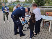 Policjant znakuje dziewczynce rower