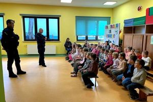W pomieszczeniu dwóch umundurowanych policjantów z grupą dzieci