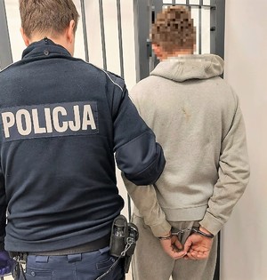 Policjant prowadzi zatrzymanego