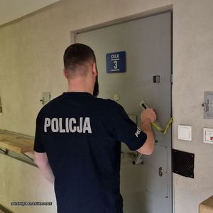 Policjant przy drzwiach celi