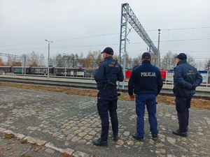 Dwóch policjantów oraz funkcjonariusz SOK przy rampie kolejowej