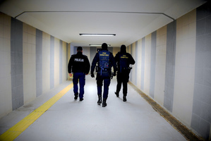 Umundurowany policjant z dwoma strażnikami ochrony kolei.