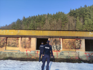 Dwaj policjanci przed zrujnowanym magazynem