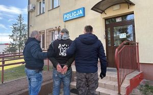 Dwóch nieumundurowanych policjantów prowadzi zatrzymanego do Komisariatu Policji
