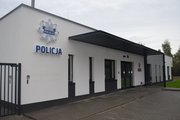 Parterowy jasny budynek z napisem Policja