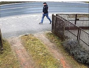Zdjęcie mężczyzny idącego chodnikiem wzdłuż jezdni
