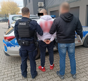 Policjanci prowadza zatrzymanego