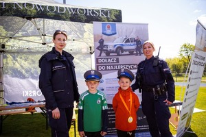 Przed namiotem wystawienniczym dwie policjantki oraz dwójka dzieci