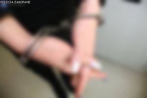 Rozmyte zdjęcie rąk skutych kajdankami