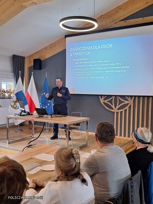 Policjant podczas prelekcji na tle ekranu