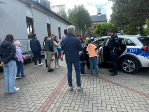 Piknik, w tle radiowóz i policjanci