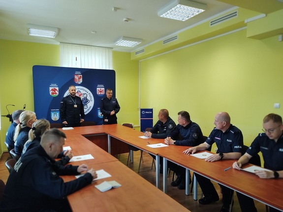 Policjanci na sali konferencyjnej przy stolach