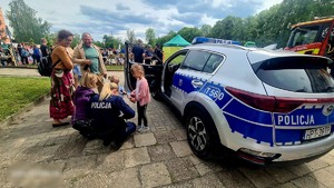 Radiowóz ze zgromadzoną grupą ludzi z dziećmi na pikniku