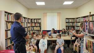 Umundurowany policjant w pomieszczeniu na spotkaniu z dziećmi