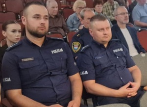 Dwóch policjantów na widowni sali konferencyjnej