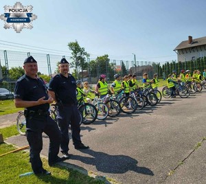 Dwóch policjantów i grupa uczniów na rowerach