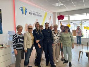 Pozujące do zdjęcia w sali konferencyjnej seniorki oraz dwie policjantki