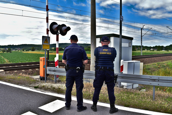 Policjant oraz strażnik ochrony Kolei przed przejazdem kolejowym