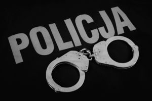Kajdanki leżące na bluzie z napisem policja