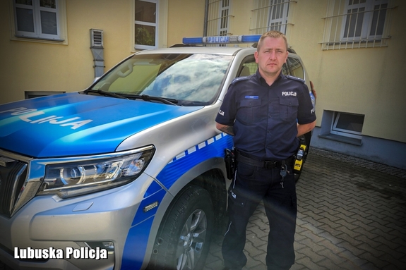 Policjant na tle terenowego radiowozu