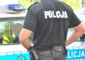 Widziany od tyłu policjant na tle radiowozu