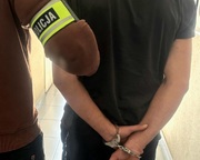 Policjant prowadzi zatrzymanego