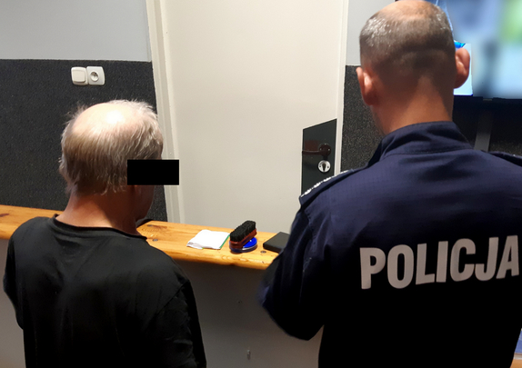 Policjant z zatrzymanym mężczyzną