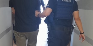 Policjant prowadzi zatrzymanego