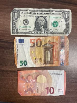 Rozłożone trzy banknoty euro oraz jeden dolar